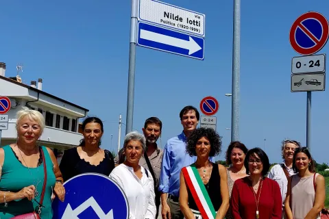 Foto di gruppo sotto il cartello della civica via