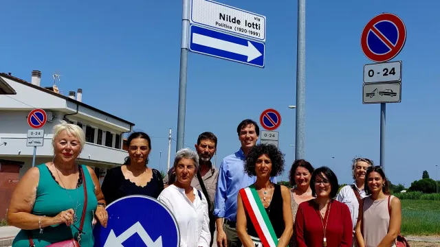 Foto di gruppo sotto il cartello della civica via